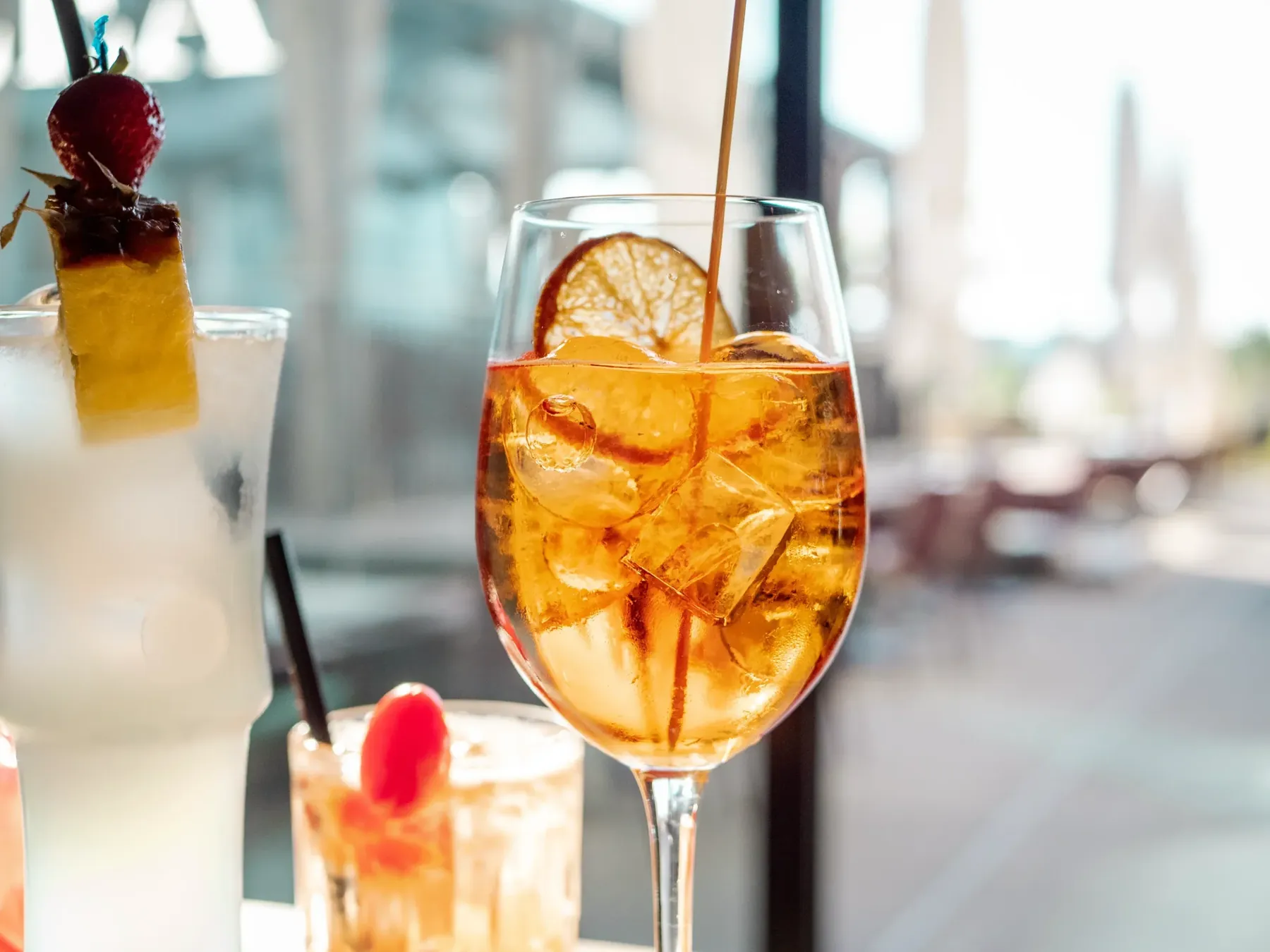Aperol-Glas mit Eis und Zitrone im Gegenlicht