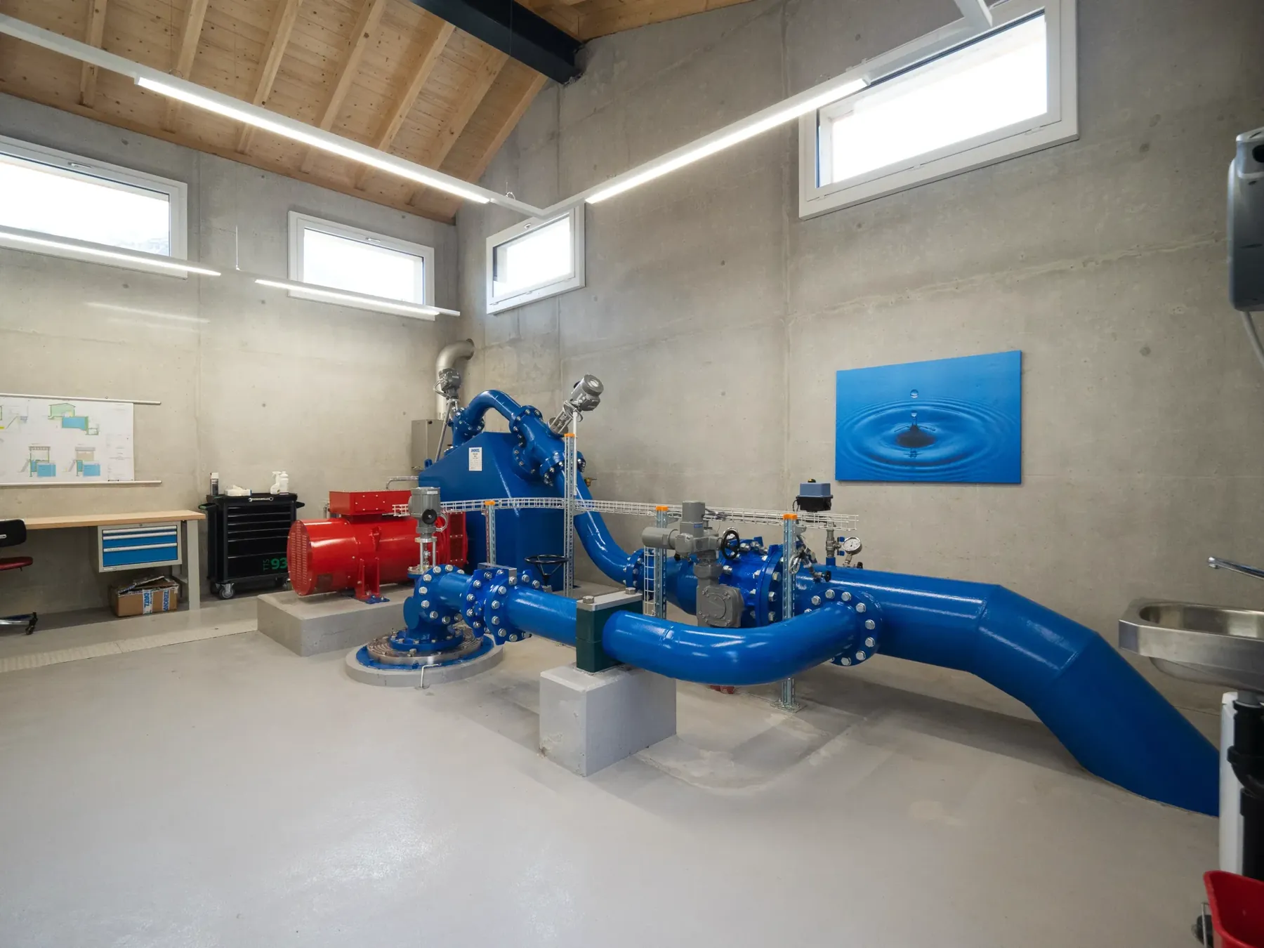 Turbinenhaus mit blauen Rohrleitungen unter Holzdach