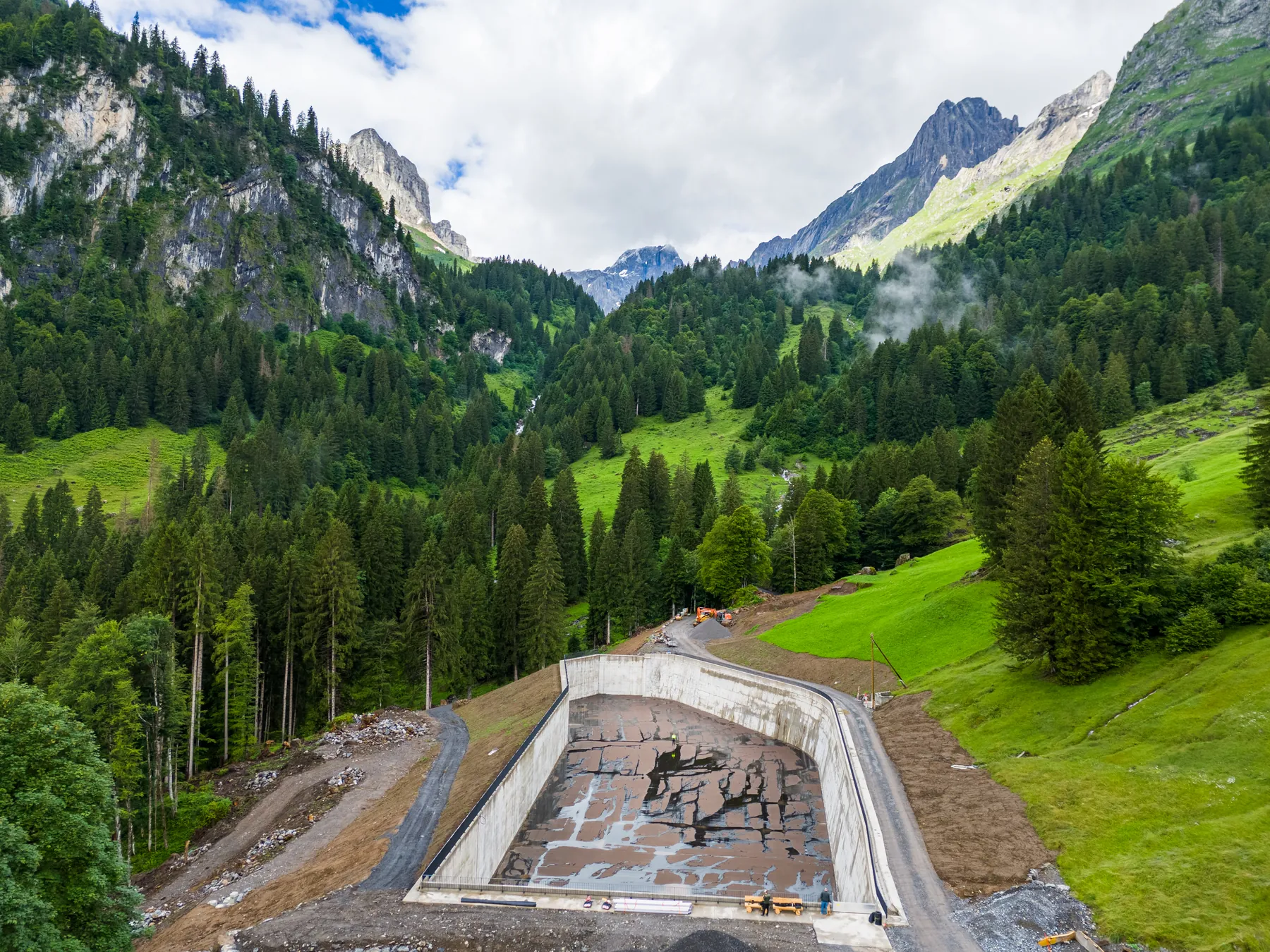 Baugrube einer Wasserfassung im Bergtal aus der Luft