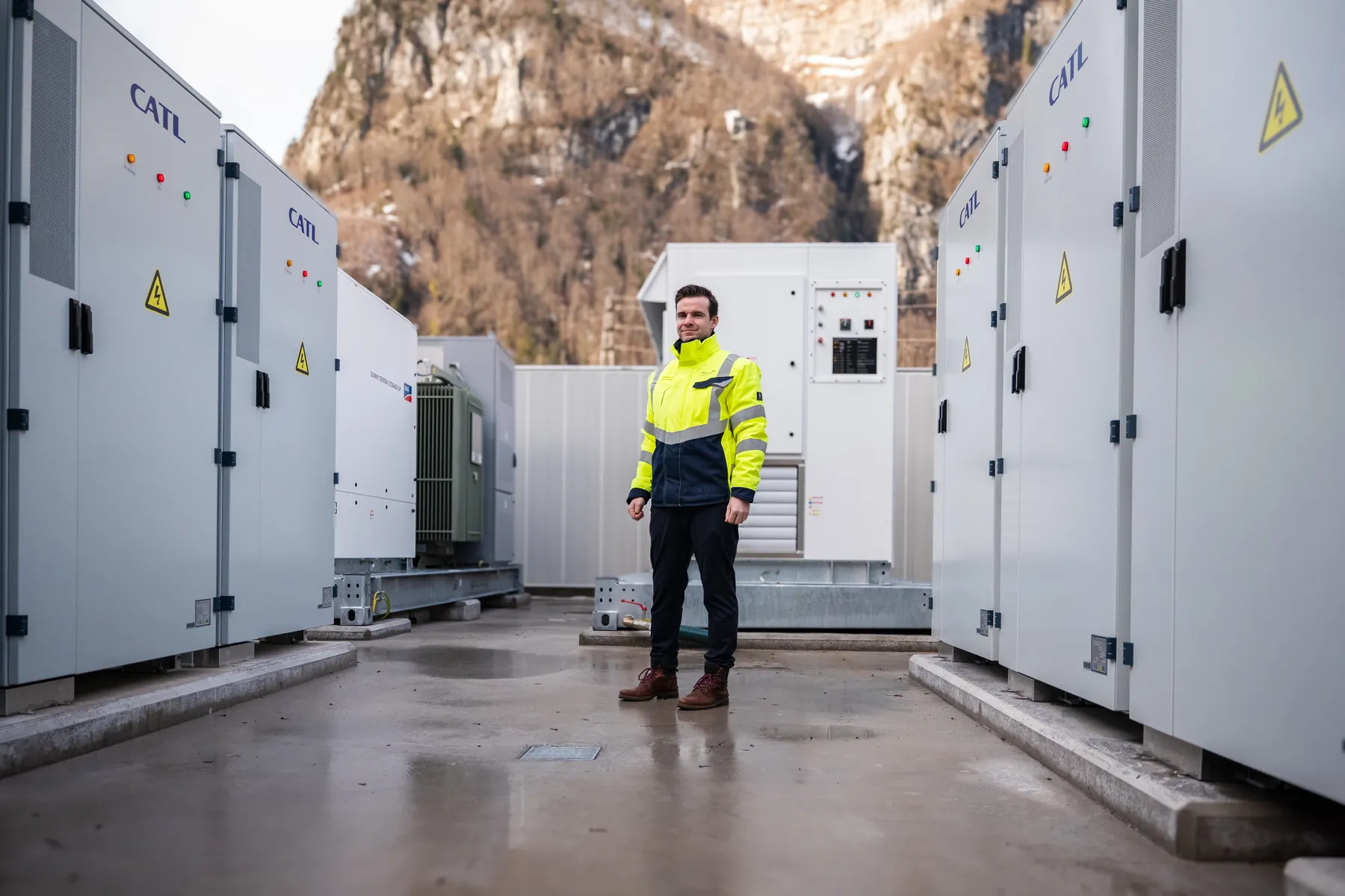 Techniker vor weissen Batteriespeicher-Modulen in einer Halle
