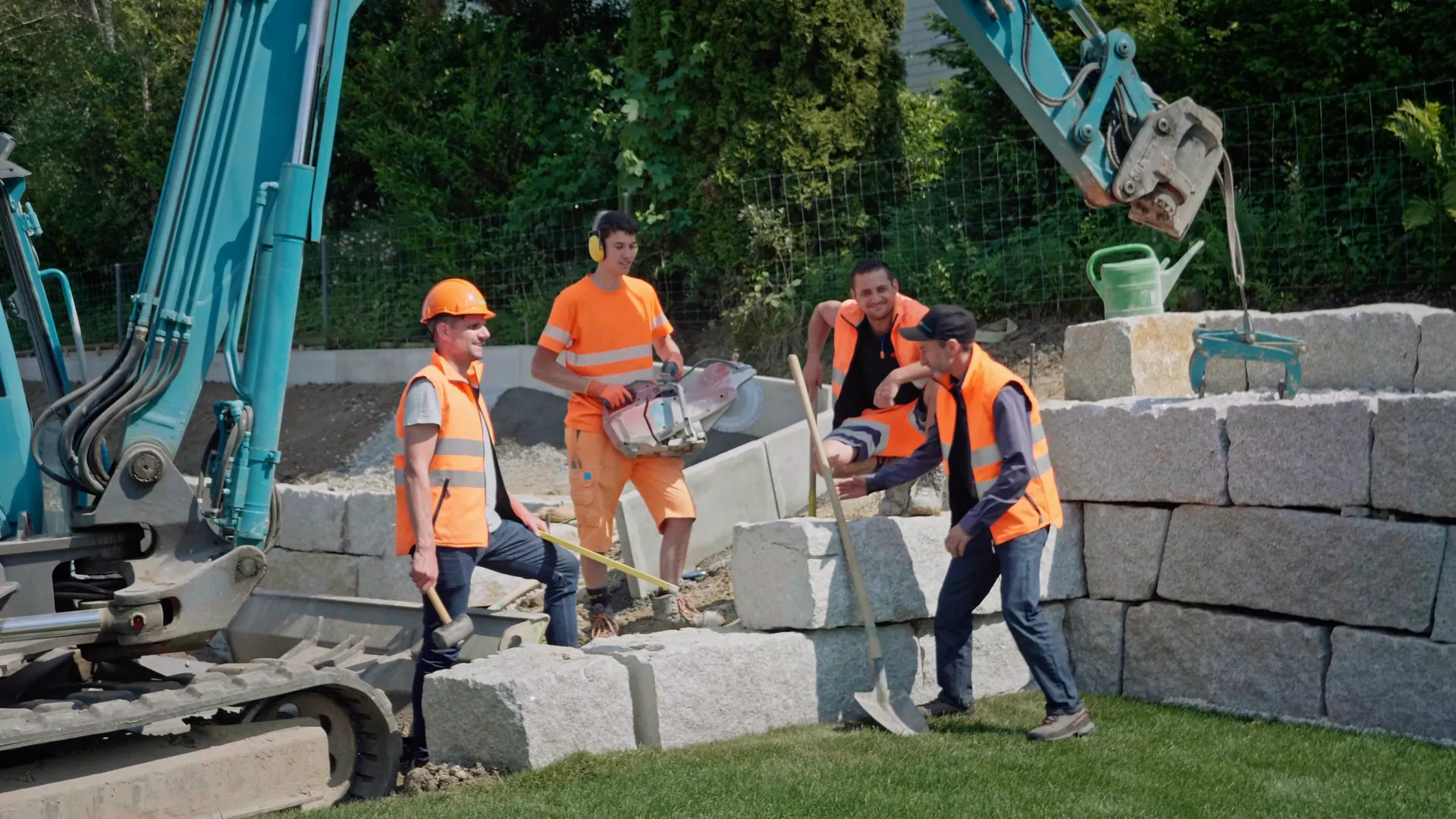 Bauteam setzt Granitblöcke für eine Stützmauer
